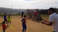 Notable ejemplo de niños que cultivan el fútbol en una cancha ubicada en la cúspide de un cerro.